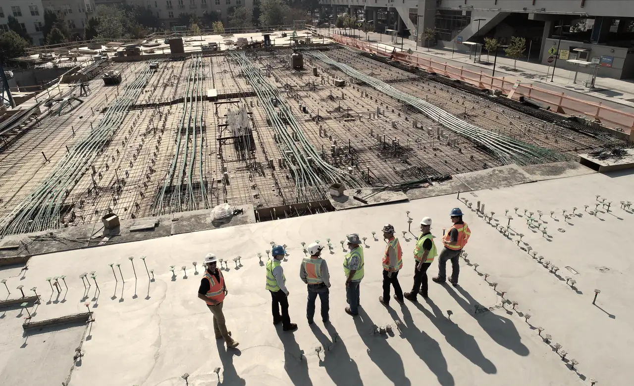 A site team standing on a completed raft foundation, reinforcement laid out behind them.
